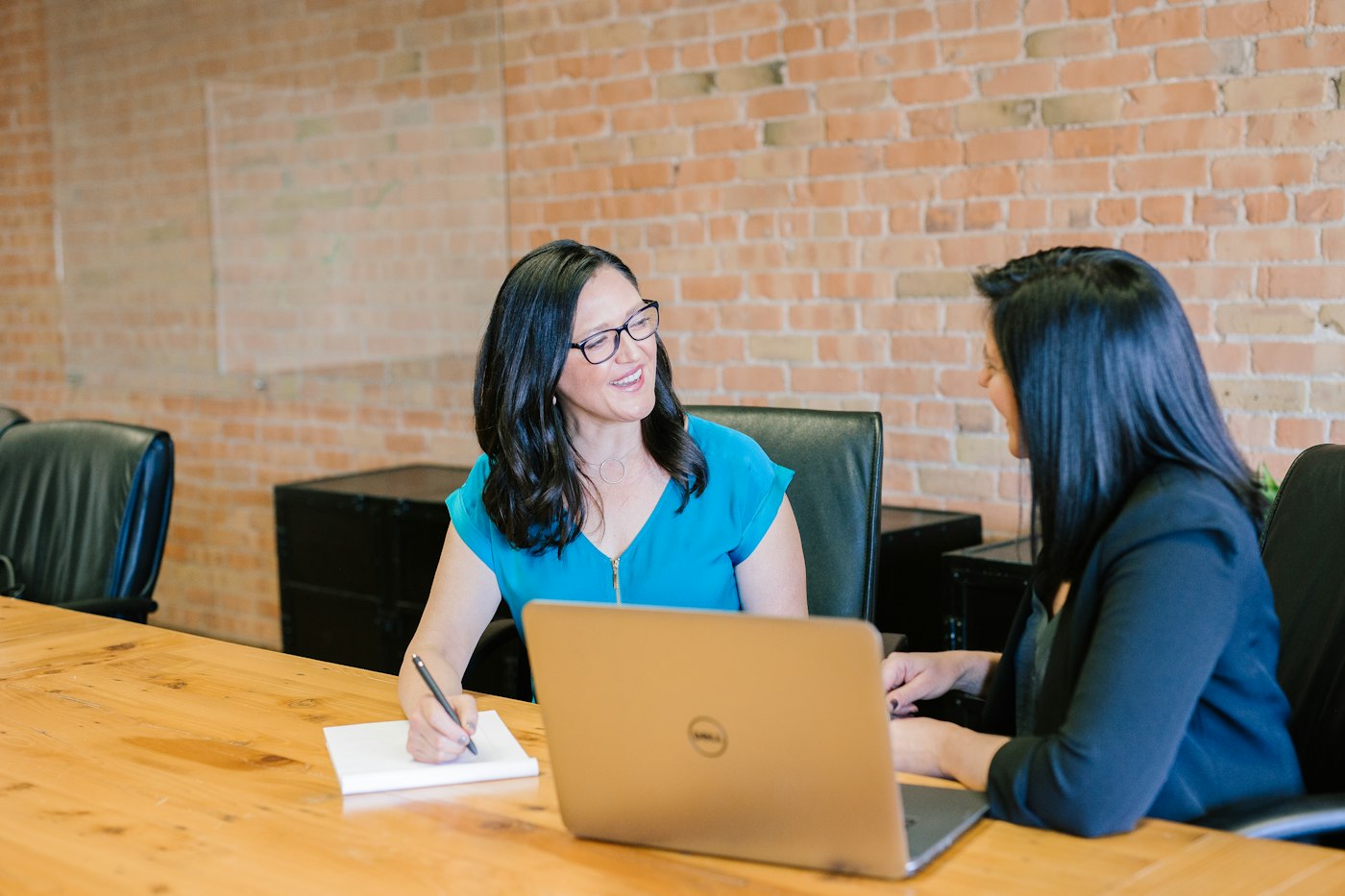 Two people talking at a table, suggesting an appointment
