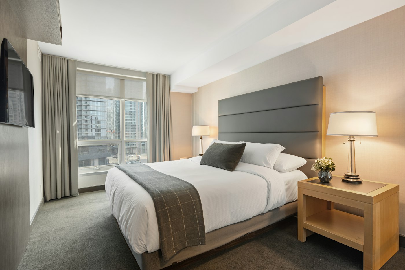 A bright hotel room with a made bed